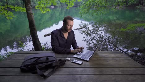Businessman-working-with-his-laptop-in-nature-park.